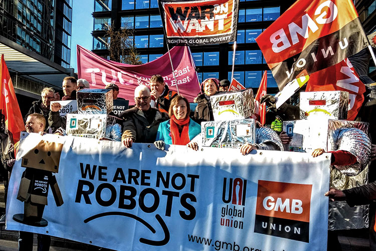 Protestors with sign reading "We are not robots"