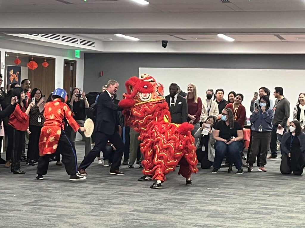 Lion dancing and people reaching into his mouth